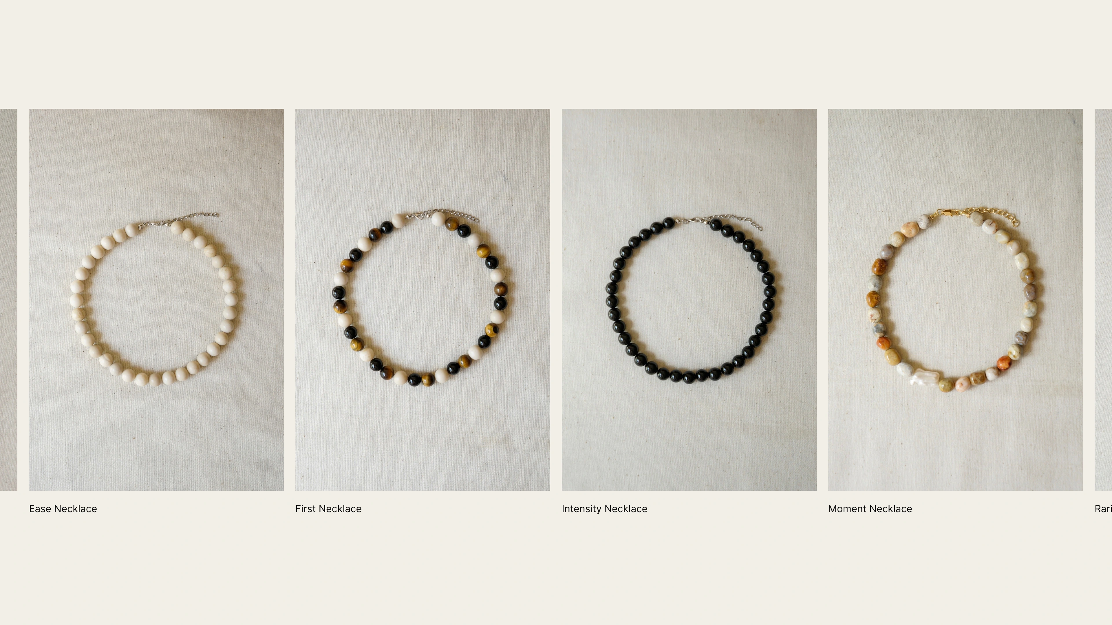 The first collection: eight GRAIN necklaces laid out on linen with their names