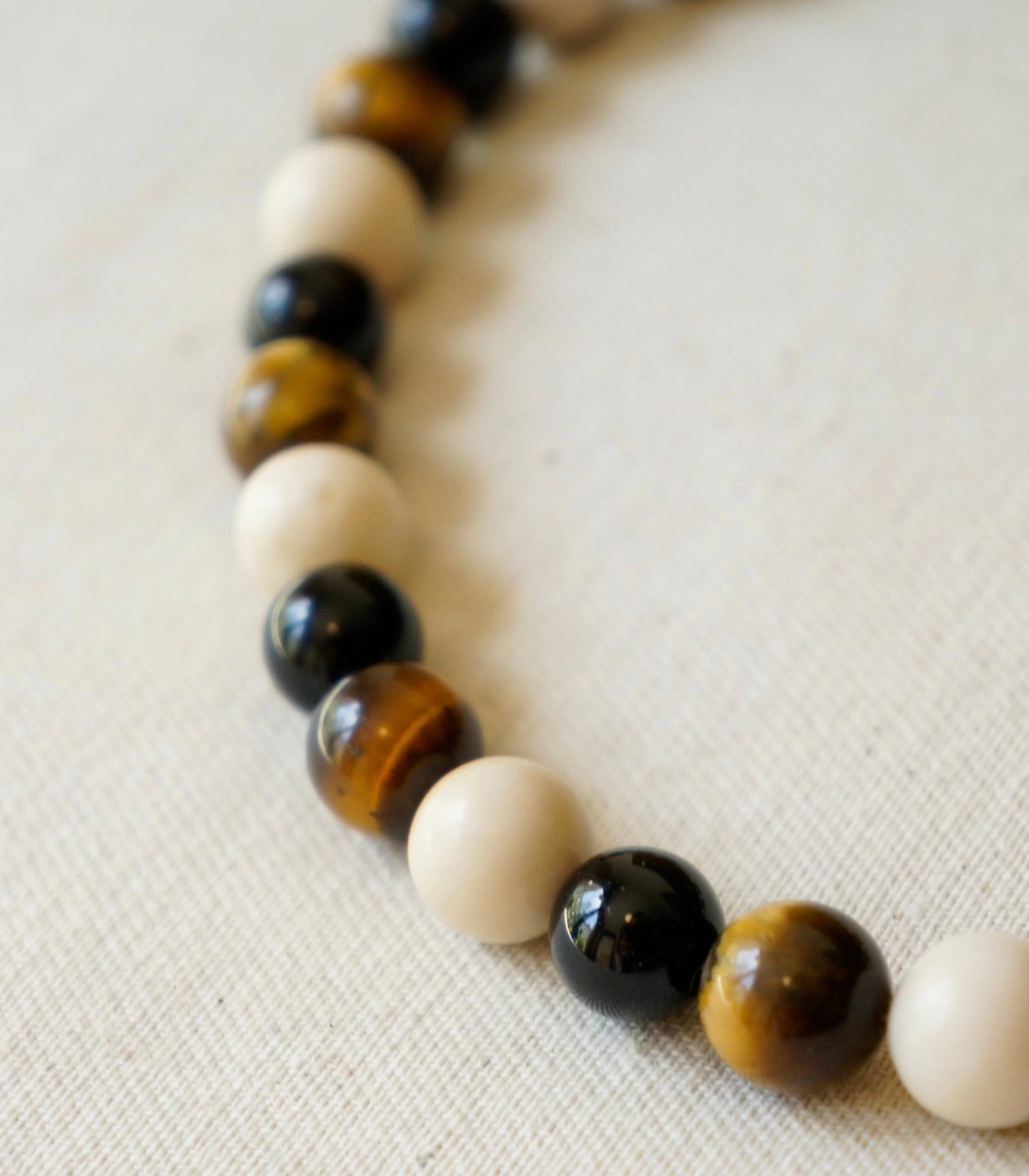 Close-up of the First necklace beads on linen