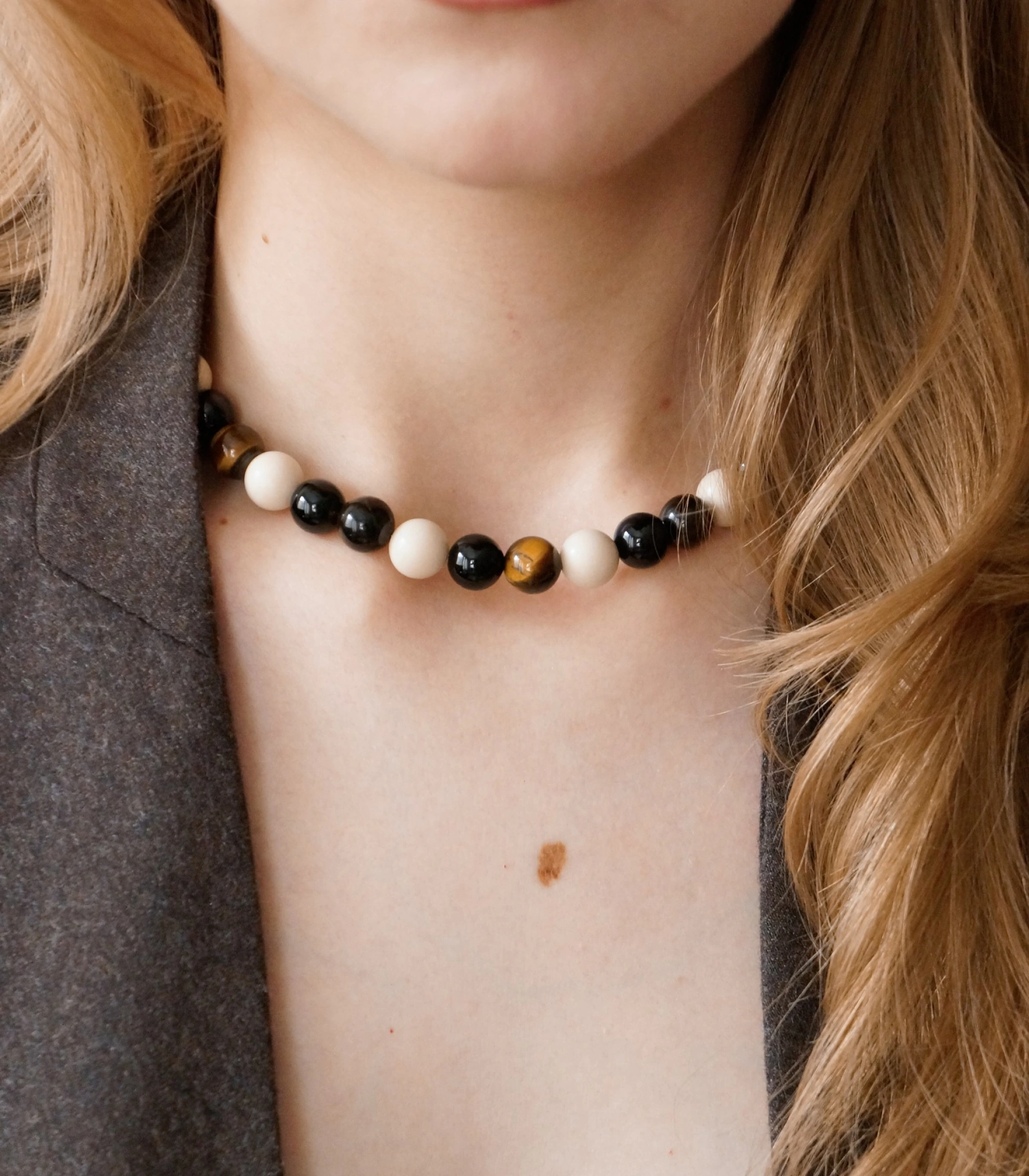 The First necklace of onyx, tiger's eye and fossil stone, worn