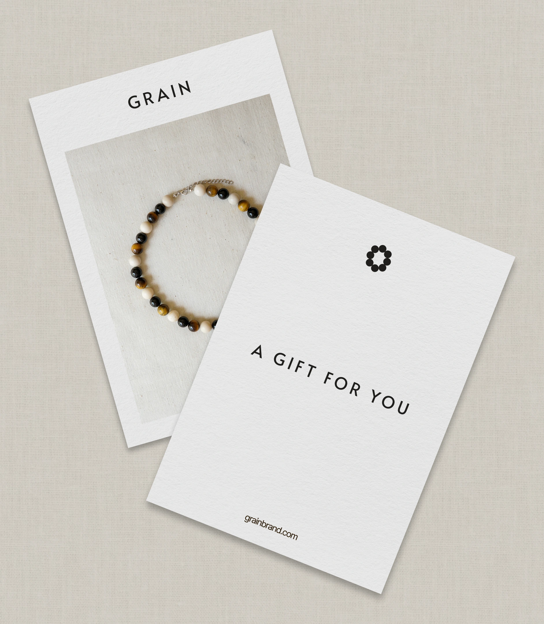GRAIN gift card and an 'A gift for you' card with the bead symbol beside a First bracelet