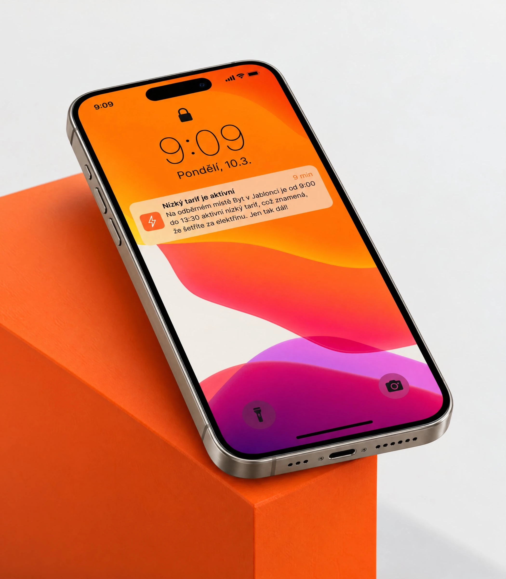 Lock screen with the 'Nízký tarif je aktivní' notification, phone leaning on an orange block